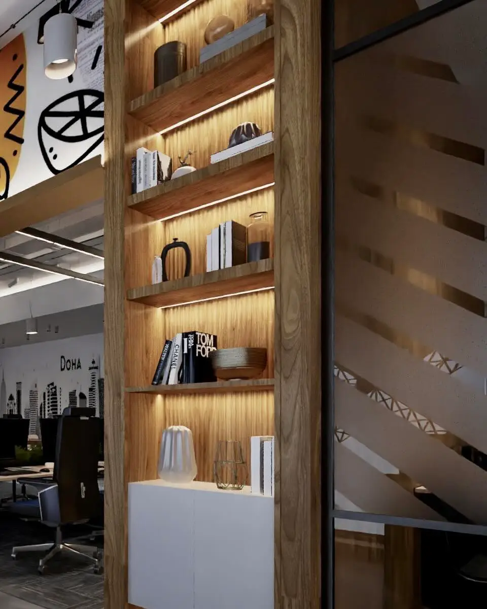 Close-up of lit timber shelving with books and ceramics