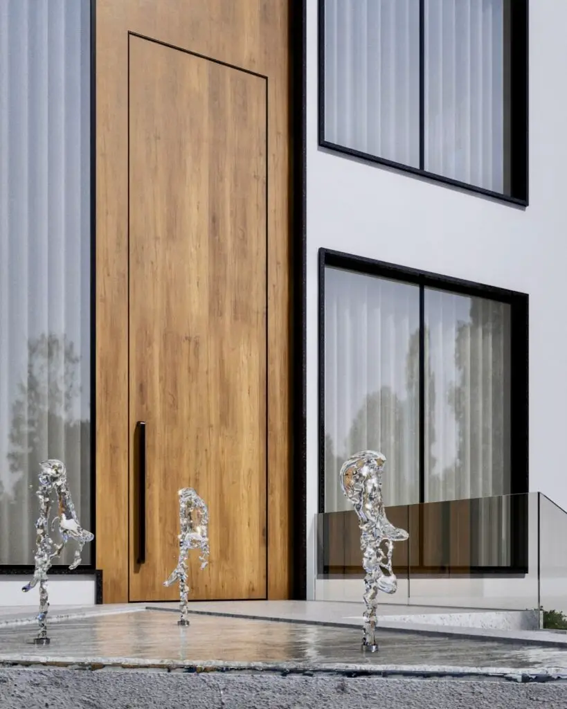 Tall timber front door beside a shallow water feature with glass sculptures