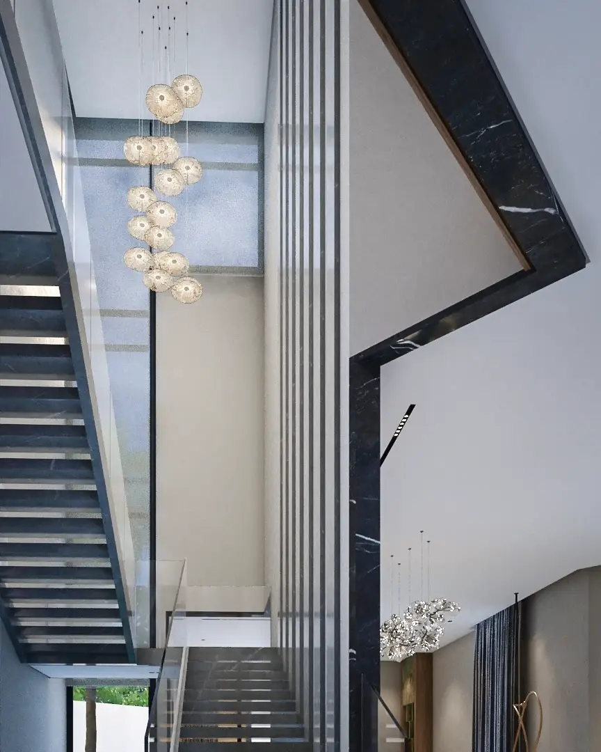 Stair void with a cluster pendant light, black marble frame and slim vertical fins