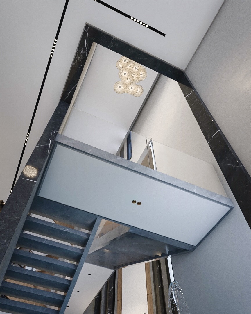 Looking up the stairwell framed in black marble, with a glass balustrade and cluster pendant
